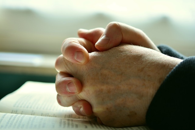 Handen rusten op het opengeslagen gastenboek van de Erkerkerkerkerk